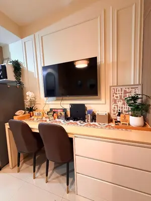 a kitchen with a table with chairs and a television at Relaxing 1BR Condo near MOA & NAIA with WiFi, PS4, Karaoke in Manila