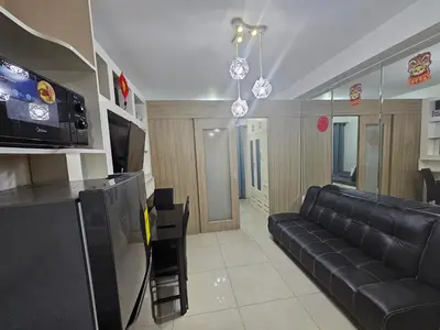 a living room with a black couch and a tv at Shore Residences Tower D Viann in Manila