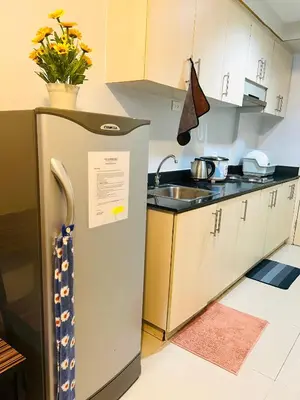 a small kitchen with a sink and a refrigerator at Sea Residences Elegant Place by Bella in Manila