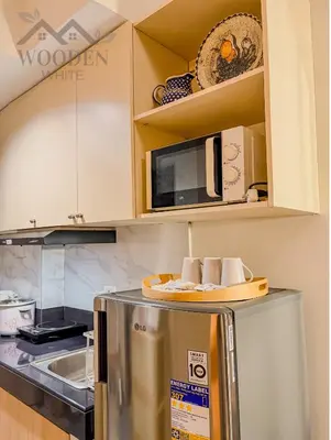 a kitchen with a microwave and a refrigerator at Wooden White in Manila