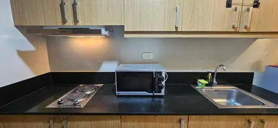 a kitchen with a microwave and a sink at The Executive Suites by PJTai Realty Shell002 - 1BR in Manila