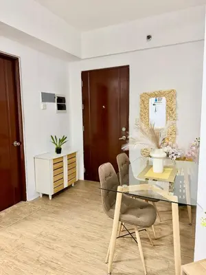 a dining room with a glass table and chairs at The Global Nest at Anuva Modern 1BR with Pool in Manila