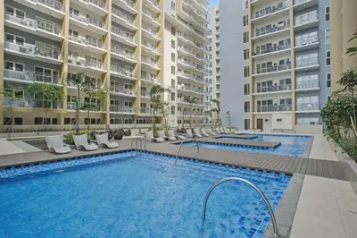 a swimming pool in front of some apartment buildings at Sunset Retreat - 4 Bedroom Home near Solaire 14pax in Manila