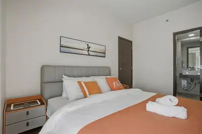 a bedroom with a large bed with orange pillows at Sunset Retreat - 4 Bedroom Home near Solaire 14pax in Manila