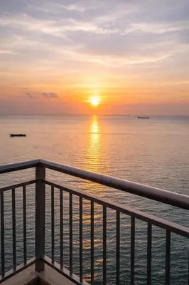 a sunset over the ocean from a pier at Sunset Retreat - 4 Bedroom Home near Solaire 14pax in Manila