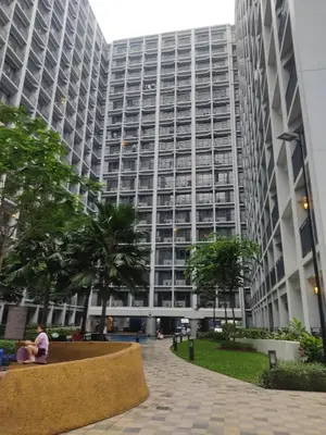 a person sitting in front of a large building at Shore 2 Residences Tower 1 JayDa in Manila