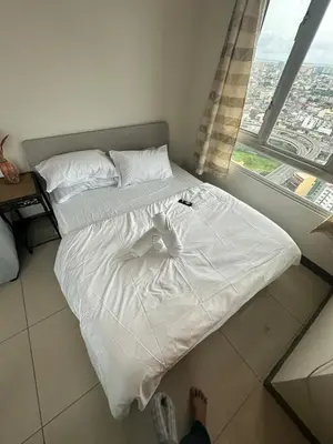 a person standing on a bed in a bedroom at Next Abode Modern Stay at TheBeaconMakatiRoces in Manila