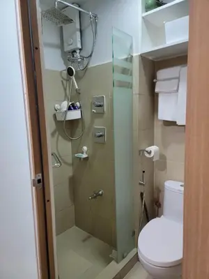 a bathroom with a toilet and a glass shower at The Nook at the Shore in Manila