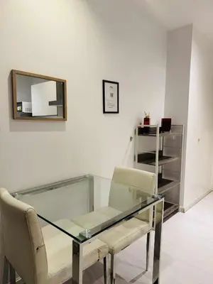 a glass table with two chairs and a mirror at The Gramercy Residences in Manila
