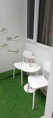 a table and two chairs and a table and green carpet at DIRECT TO POOL Shore Residences by heart in Manila