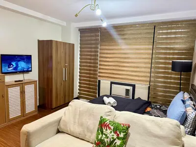 a person laying on a couch in a living room at The Gramercy Residences in Manila