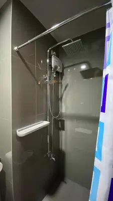a shower in a bathroom with a glass wall at Cozy & Affordable Stay in Air Residences in Manila