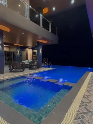 a large swimming pool in a building with a house at Bella Tamara Private Resort in Binangonan