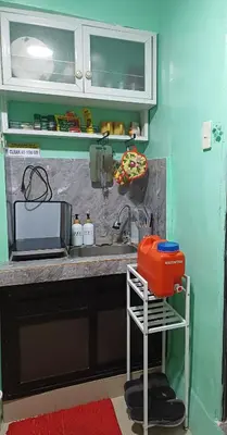 a kitchen counter with a sink and a microwave at Dencios transient