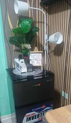a desk with a lamp and a plant on it at Dencios transient
