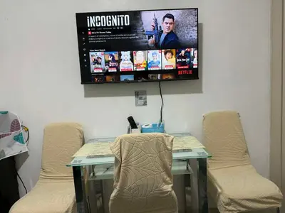 a room with a table with chairs and a tv on the wall at Staycation at Sea Residences MOA Pasay City in Manila