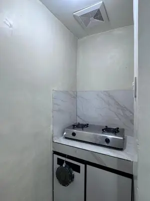 a kitchen with a stove on a white wall at Hidden Leaf Private Resort in Dasmariñas
