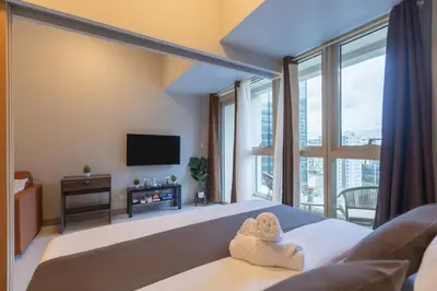 a bedroom with a bed with a towel on it at CozyBGCCondoKing BedFast WiFiSteps fromUptownMall in Manila