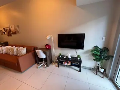 a living room with a couch and a flat screen tv at CozyBGCCondoKing BedFast WiFiSteps fromUptownMall in Manila