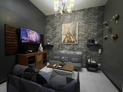 a living room with couches and a flat screen tv at The Gramercy Residences by YYESS in Manila