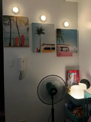 a room with a fan and pictures on the wall at ALFA staycation at Shore 2 tower 1 Pasay City in Manila