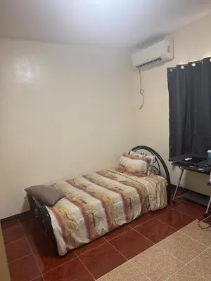 a bed sitting in a room with a tv at Easy Escape in Manila