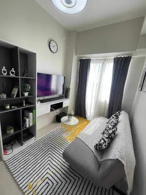 a living room with a couch and a television at Condo Transient by Eugenio Tan in Manila