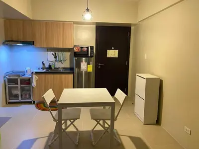 a small kitchen with a table and a refrigerator at Vacation at Tolentino Residence in Manila