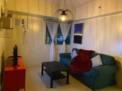 a living room with a blue couch and a table at Vacation at Tolentino Residence in Manila