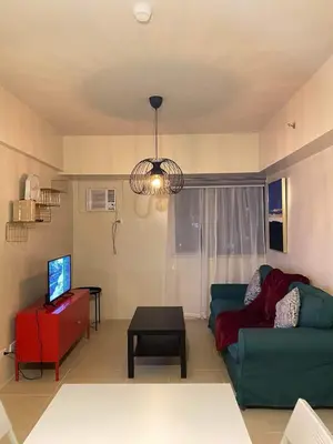 a living room with a green couch and a table at Vacation at Tolentino Residence in Manila