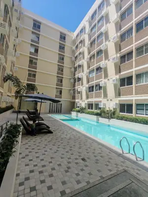 a swimming pool in front of a building at Escape to Nature Studio Unit in Puting Kahoy