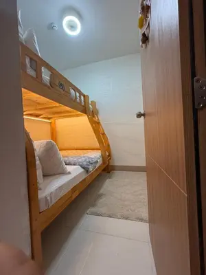 a small room with two bunk beds and a door at Shore Bliss Staycation in Manila
