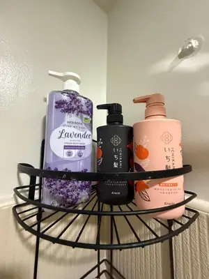 a shelf with three bottles of soap and shampoo at stylish 2BR Condo Near NAIA in Manila