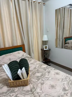 a basket of books on a bed with a mirror at stylish 2BR Condo Near NAIA in Manila
