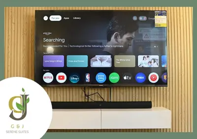 a flat screen tv with a presentation on a wall at G & J Serene Suites in Tanza
