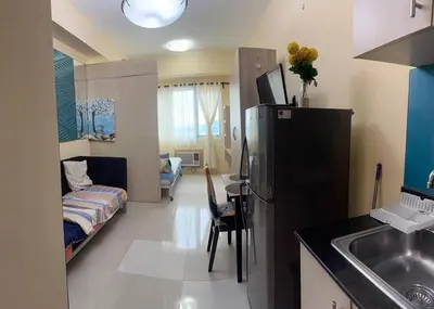 a kitchen with a refrigerator and a living room at Sea Residences Tower B Condotel Look F0R MaV in Manila
