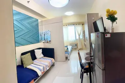 a living room with a couch and a refrigerator at Sea Residences Tower B Condotel Look F0R MaV in Manila
