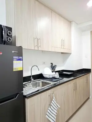 a kitchen with a sink and a refrigerator at Oasis at Shore Residences in Manila
