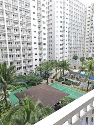 a tennis court in front of large buildings at Oasis at Shore Residences in Manila