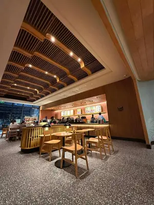 a restaurant with wooden tables and chairs and people in the background at Sea Residences - Mall of Asia 829B by Forever-mc Condotel in Manila