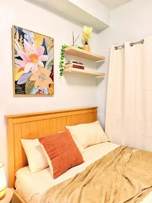 a bedroom with a bed and a painting on the wall at Mariah Relaxing Minimalist Condo at Filinvest City Alabang in Manila