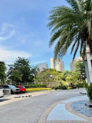 a palm tree in a parking lot with buildings at Mariah Relaxing Minimalist Condo at Filinvest City Alabang in Manila