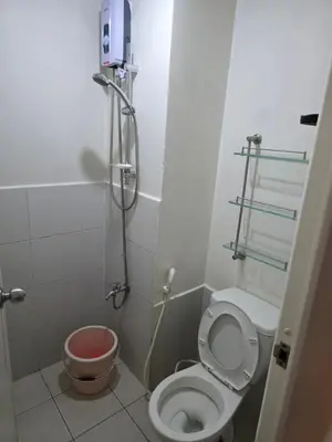 a small bathroom with a toilet and a shower at Staycation All In in Manila