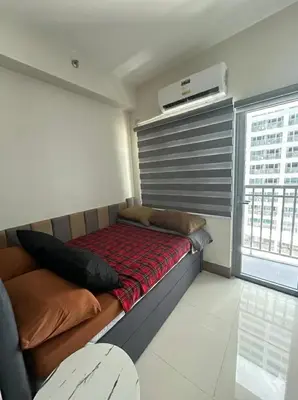 a small bedroom with a bed and a window at Fame Residences Staycation in Manila