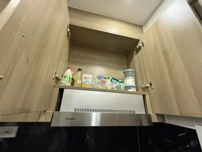 a kitchen with a stove top oven in a cabinet at Fame Residences Staycation in Manila