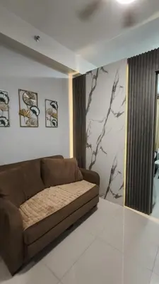 a living room with a brown couch in a room at Fame Residences Staycation in Manila