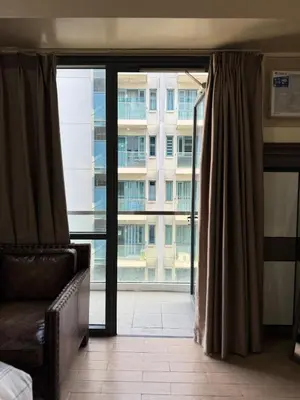a room with a large window with a couch and a large building at 81 Newport Across International Airport Terminal 3 C1-7O in Manila