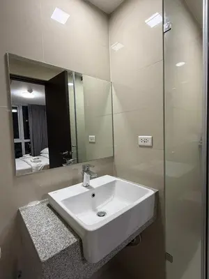 a bathroom with a white sink and a mirror at Condo in BGC by MichVist - Uptown Parksuites Tower 2 in Manila