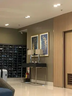 a room with a table and a wall with shelves at Juliza's MOA Staycation in Manila