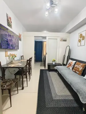 a living room with a bed and a dining room at Juliza's MOA Staycation in Manila